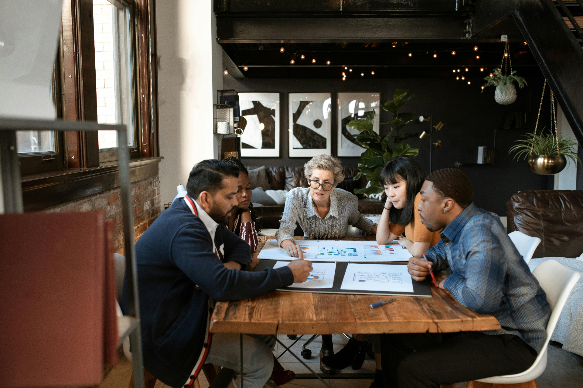 A diverse small group in deep discussion around a table
