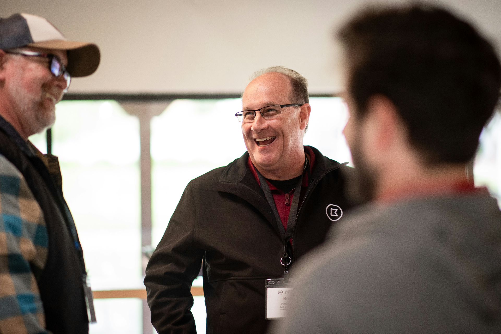 Three men in genuine conversation at a community gathering